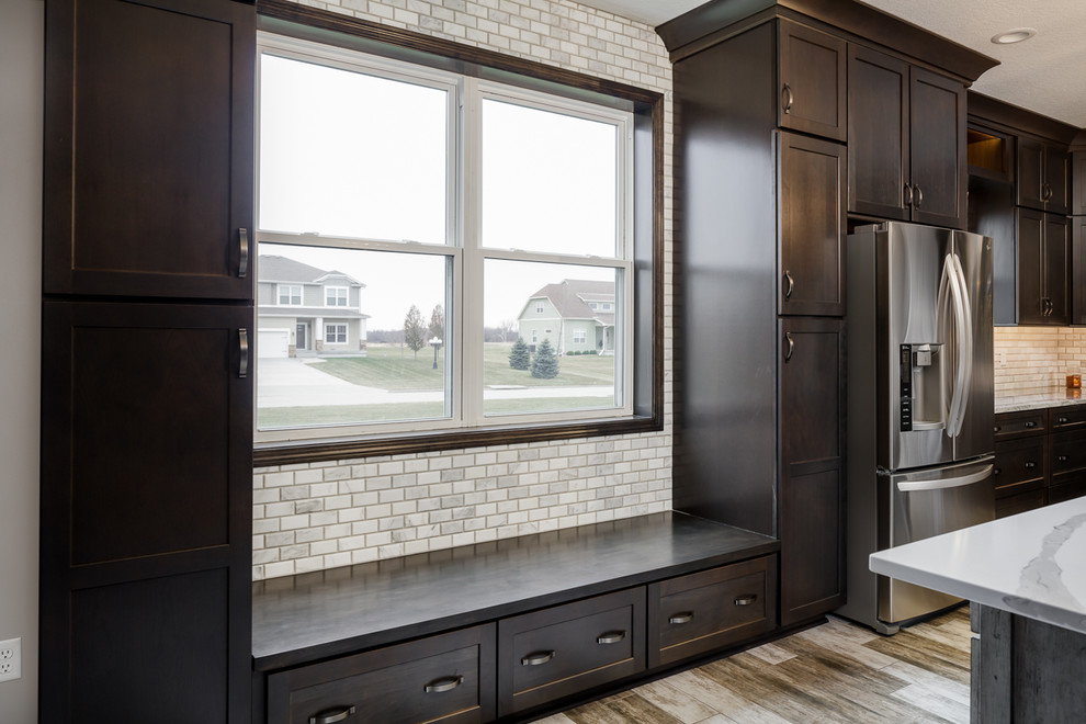 Mid-sized transitional l-shaped ceramic tile and multicolored floor eat-in kitchen photo with an undermount sink, shaker cabinets, medium tone wood cabinets, quartz countertops, white backsplash, marble backsplash, stainless steel appliances, an island and white countertops