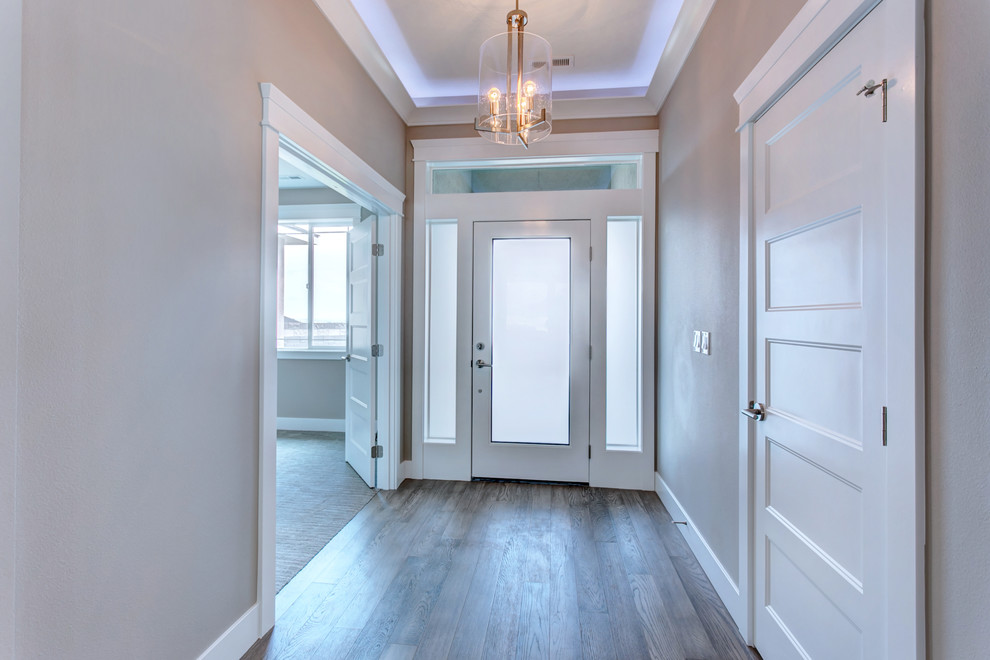 Entry hall - small transitional medium tone wood floor and gray floor entry hall idea in Seattle with gray walls and a white front door