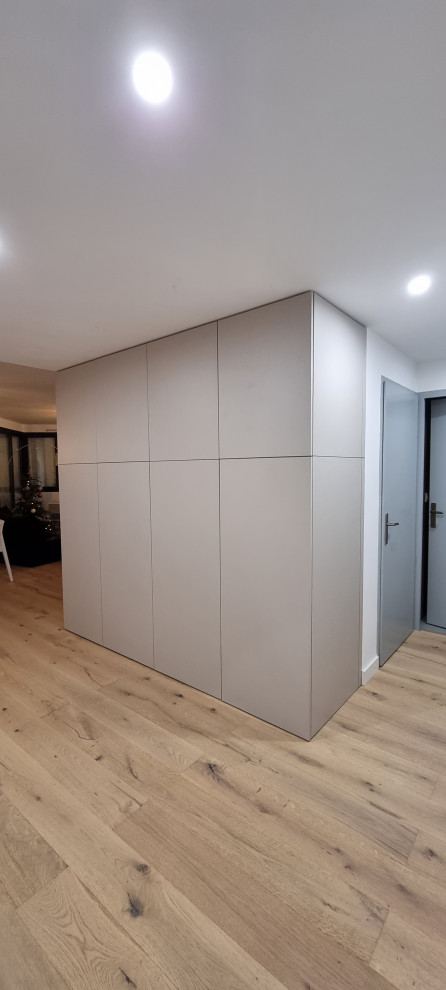 Design ideas for a small contemporary gender-neutral storage and wardrobe in Montpellier with beaded inset cabinets, beige cabinets, laminate floors and recessed.