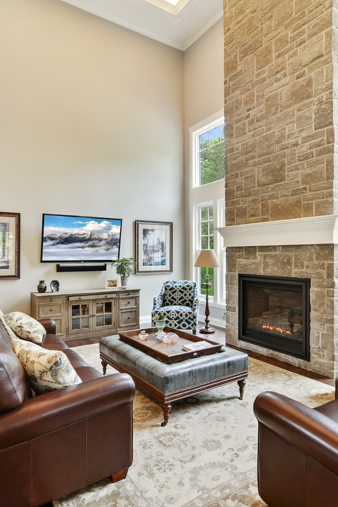 Design ideas for a large traditional open concept family room in New York with grey walls, dark hardwood floors, a standard fireplace, a brick fireplace surround, a freestanding tv and black floor.