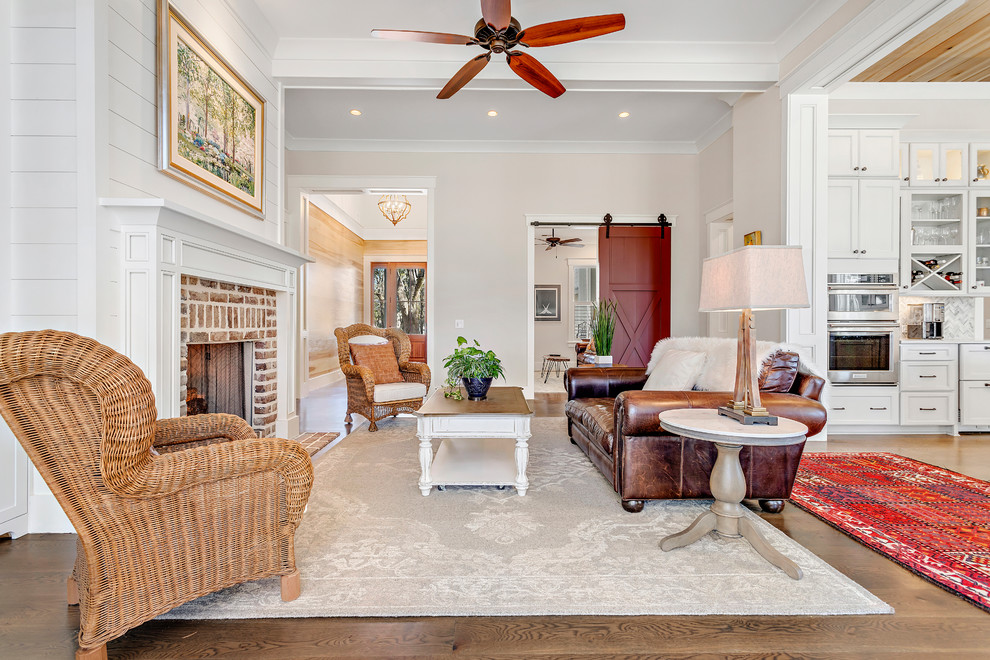 Living room - large country formal and open concept medium tone wood floor and brown floor living room idea in Charleston with beige walls, a standard fireplace and a brick fireplace