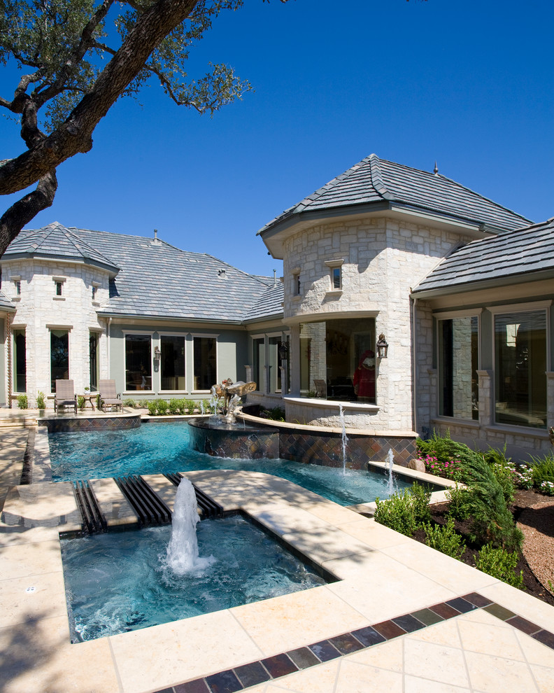 Inspiration for a mid-sized traditional courtyard custom-shaped pool in Austin with a water feature and decking.