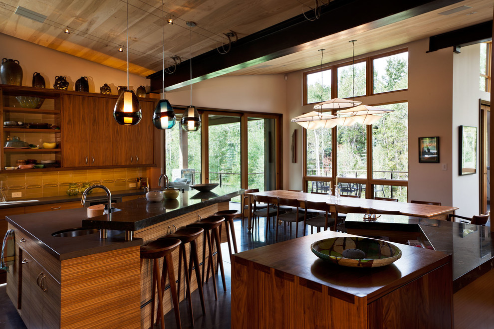 Inspiration for an expansive asian galley kitchen in Denver with a single-bowl sink, flat-panel cabinets, dark wood cabinets, stainless steel appliances, concrete floors and multiple islands.