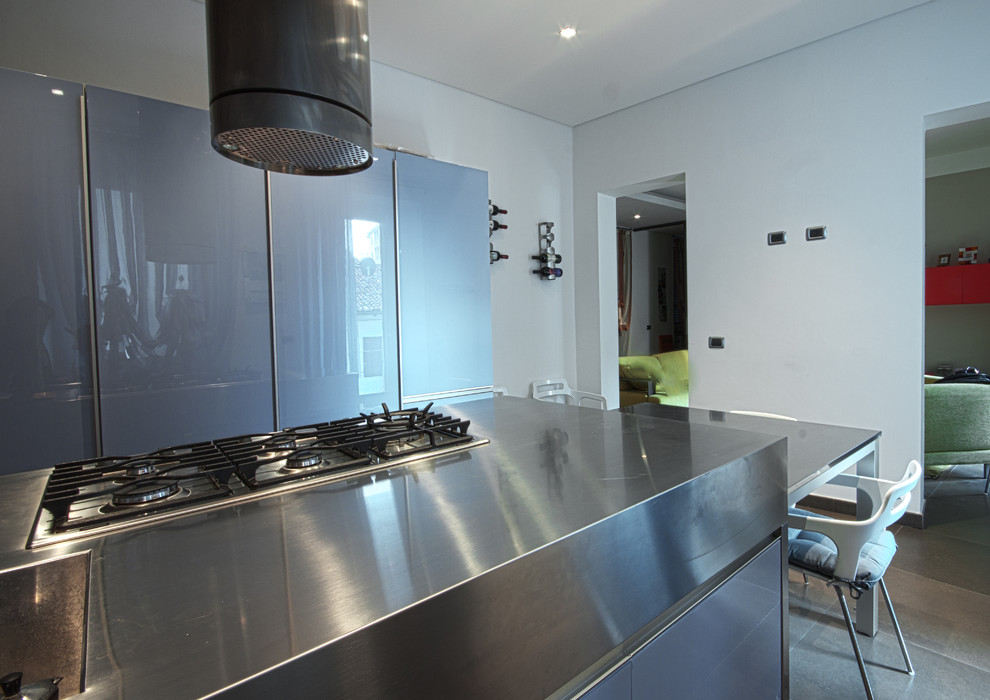 Design ideas for a mid-sized contemporary single-wall separate kitchen in Turin with an integrated sink, flat-panel cabinets, purple cabinets, stainless steel benchtops, stainless steel appliances, porcelain floors and with island.