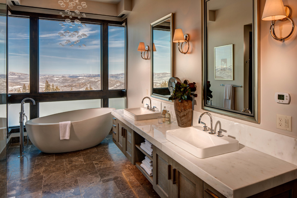 Inspiration for a large contemporary master bathroom in Salt Lake City with a vessel sink, recessed-panel cabinets, a freestanding tub, brown tile, white cabinets, ceramic floors, quartzite benchtops, brown floor, a hinged shower door and white benchtops.