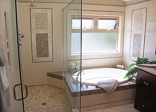 This is an example of a large arts and crafts master bathroom in Seattle with an undermount sink, dark wood cabinets, limestone benchtops, a drop-in tub, an alcove shower, multi-coloured tile, shaker cabinets, travertine floors, ceramic tile, a double vanity, a built-in vanity, white walls, multi-coloured floor, grey benchtops, a shower seat and vaulted.