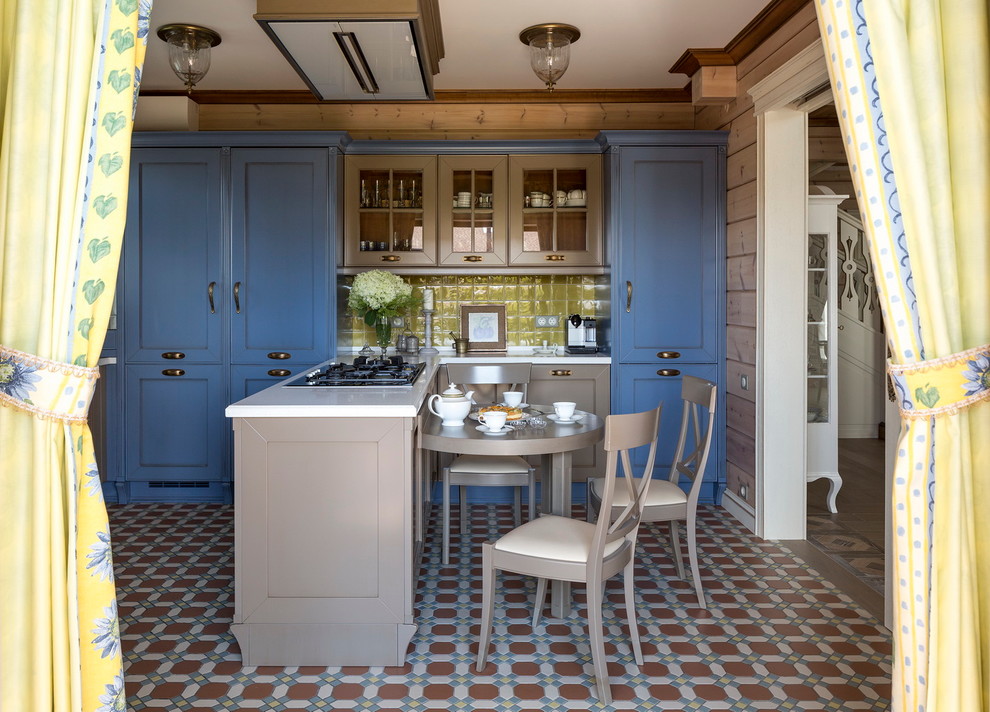 Inspiration for an eclectic l-shaped eat-in kitchen in Other with blue cabinets, ceramic floors, a peninsula and green splashback.