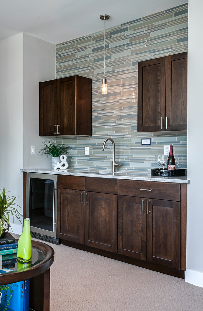 This is an example of a mid-sized contemporary single-wall wet bar in Other with an undermount sink, shaker cabinets, medium wood cabinets, granite benchtops, multi-coloured splashback, matchstick tile splashback and carpet.