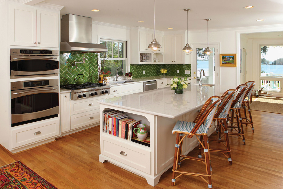 Photo of a large traditional l-shaped kitchen in Other with shaker cabinets, white cabinets, green splashback, ceramic splashback, stainless steel appliances, medium hardwood floors, with island, an undermount sink and quartz benchtops.