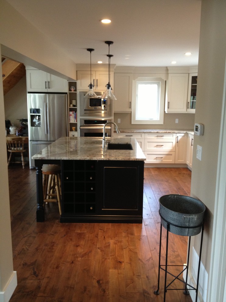 Mid-sized transitional l-shaped medium tone wood floor eat-in kitchen photo in Toronto with a double-bowl sink, shaker cabinets, white cabinets, stainless steel appliances and an island