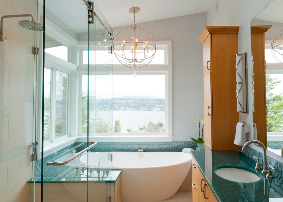 Design ideas for a mid-sized contemporary master bathroom in Seattle with an undermount sink, flat-panel cabinets, medium wood cabinets, recycled glass benchtops, a freestanding tub, a curbless shower, blue tile, ceramic tile, white walls, ceramic floors and turquoise benchtops.