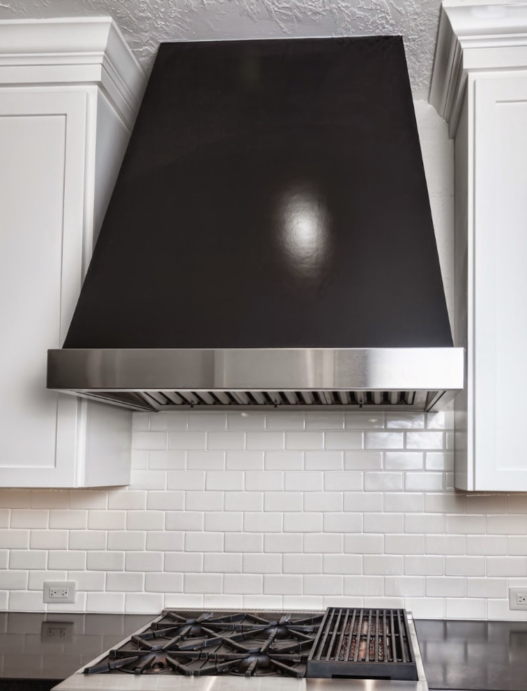 Inspiration for a large timeless l-shaped dark wood floor kitchen pantry remodel in Houston with a drop-in sink, shaker cabinets, white cabinets, solid surface countertops, white backsplash, ceramic backsplash, stainless steel appliances and a peninsula
