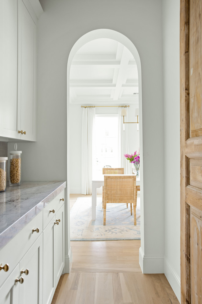 Large transitional l-shaped light wood floor, brown floor and exposed beam open concept kitchen photo in Dallas with an undermount sink, shaker cabinets, white cabinets, marble countertops, white backsplash, marble backsplash, paneled appliances, an island and white countertops
