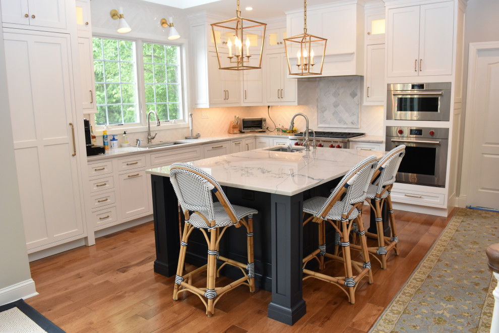 Large elegant l-shaped dark wood floor and brown floor eat-in kitchen photo in Philadelphia with a farmhouse sink, recessed-panel cabinets, blue cabinets, quartzite countertops, white backsplash, porcelain backsplash, paneled appliances, an island and blue countertops