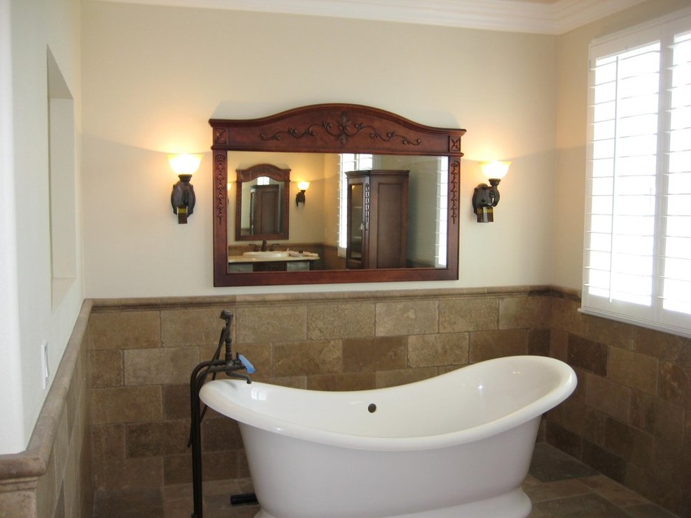 Inspiration for a mid-sized transitional master bathroom in Orange County with dark wood cabinets, a freestanding tub, brown tile, stone tile, beige walls, travertine floors, a drop-in sink and quartzite benchtops.