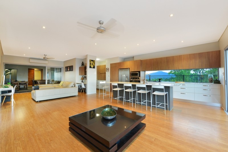 This is an example of a large asian open concept living room in Cairns with white walls and light hardwood floors.