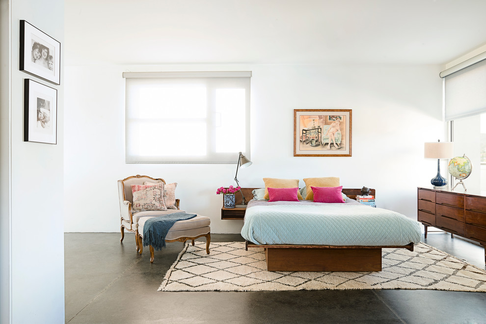 Photo of a large eclectic master bedroom in Los Angeles with white walls, concrete floors and no fireplace.