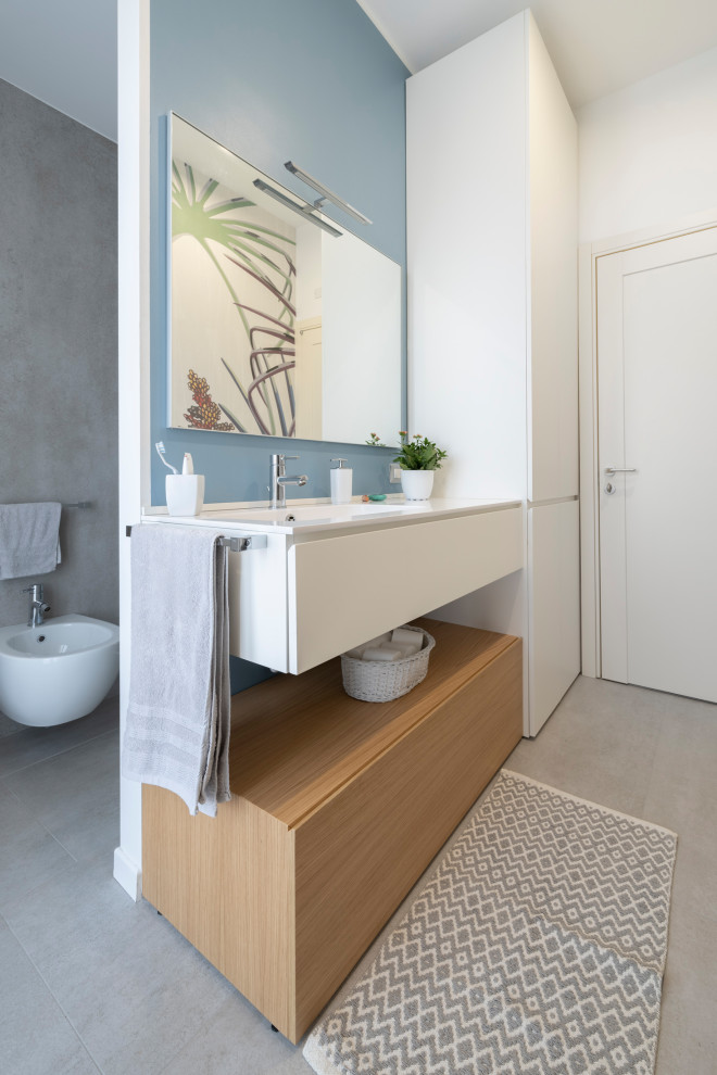 Idee per una stanza da bagno con doccia minimal di medie dimensioni con ante lisce, ante bianche, piastrelle grigie, piastrelle in gres porcellanato, pavimento in gres porcellanato, lavabo integrato, top in quarzo composito, pavimento grigio, top bianco, WC sospeso, pareti blu, un lavabo e mobile bagno sospeso