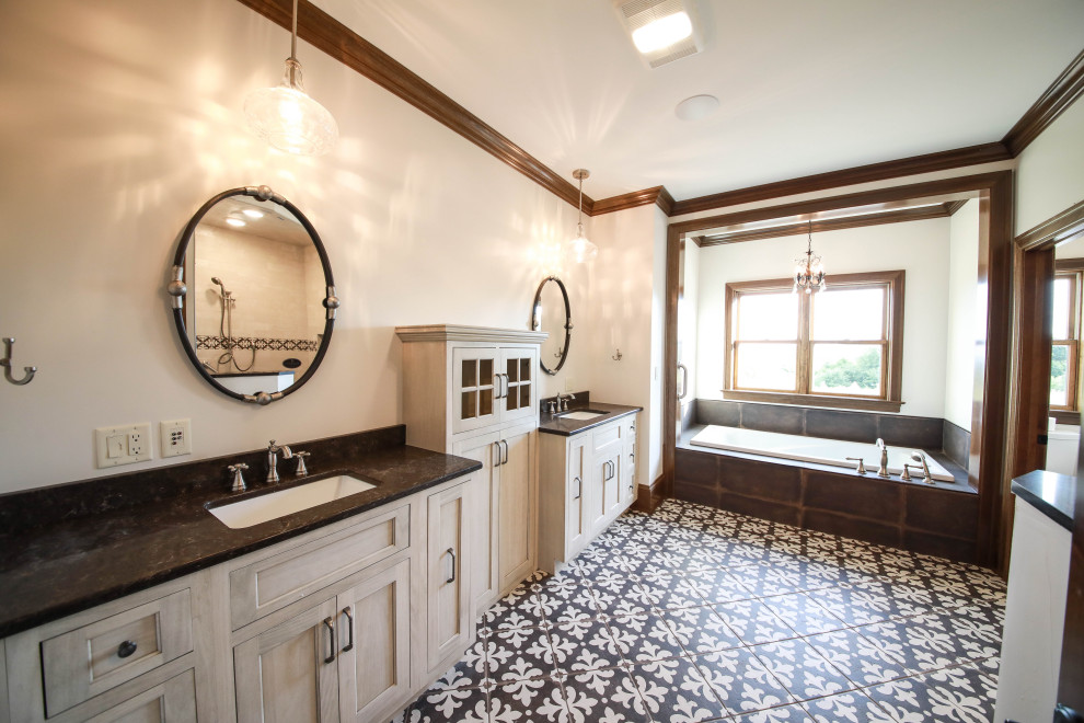 This is an example of a large country master wet room bathroom in Other with light wood cabinets, a drop-in tub, a one-piece toilet, brown tile, ceramic tile, white walls, ceramic floors, an undermount sink, granite benchtops, multi-coloured floor, an open shower, black benchtops, an enclosed toilet, a double vanity and a built-in vanity.