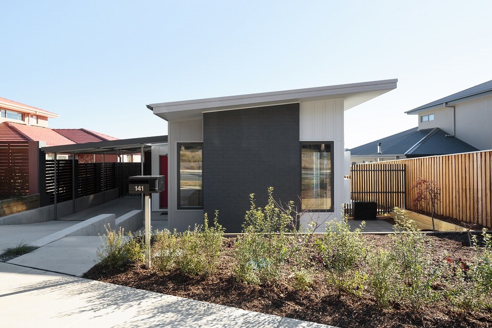 This is an example of a modern one-storey exterior in Canberra - Queanbeyan with mixed siding and a shed roof.
