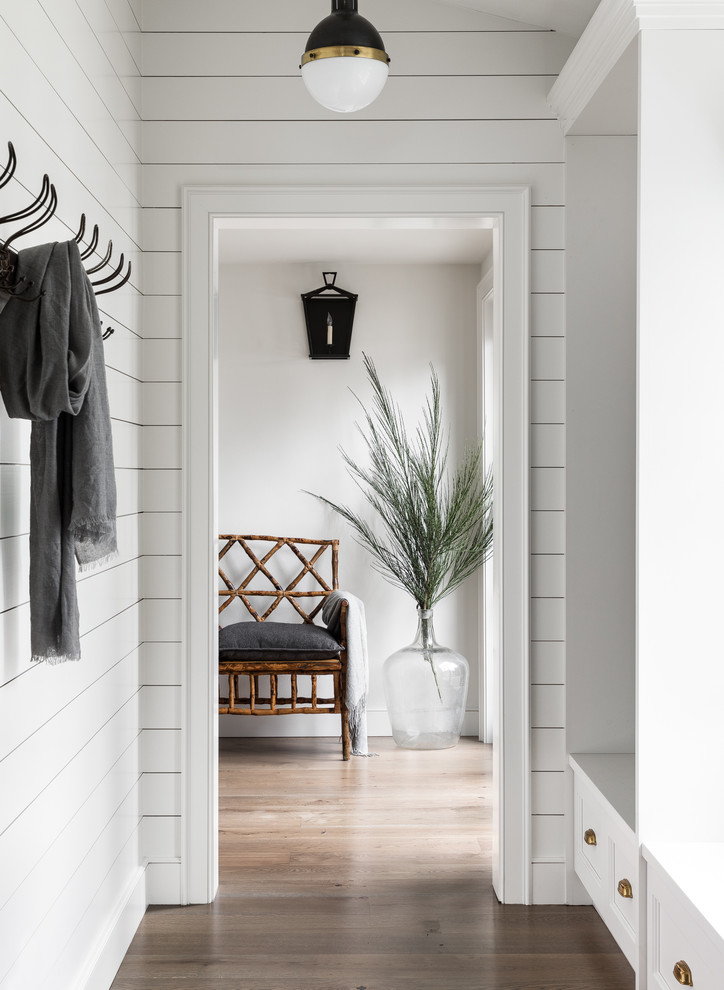 Country mudroom in Seattle with white walls and dark hardwood floors.