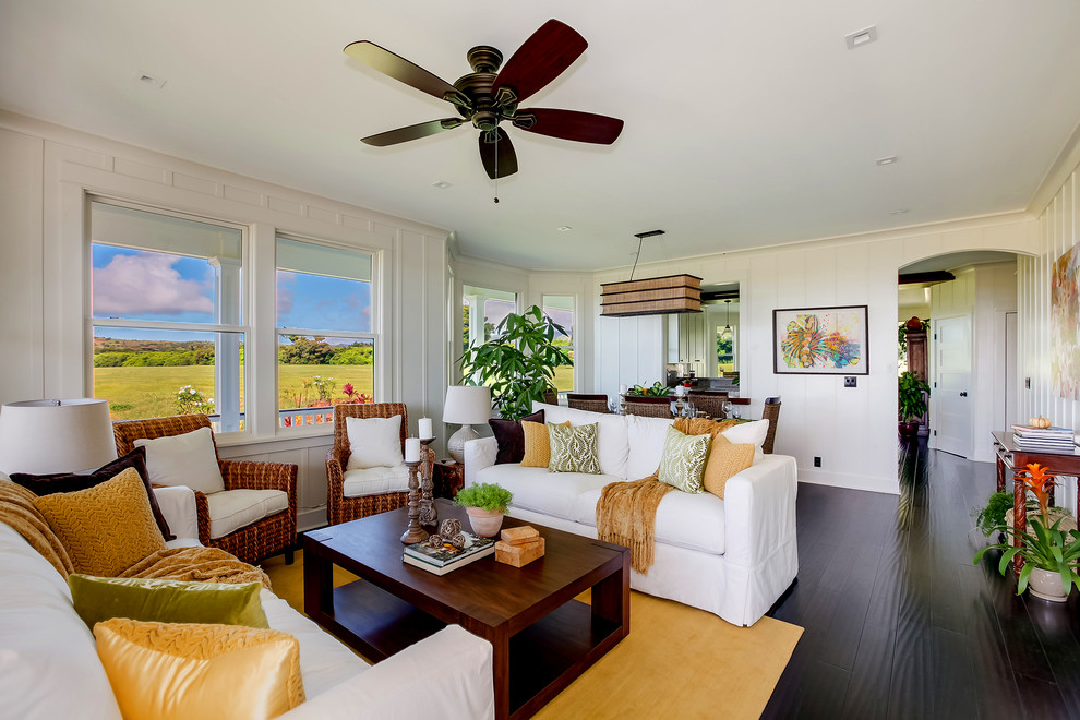 This is an example of a mid-sized beach style open concept living room in Hawaii with white walls, bamboo floors, no fireplace, no tv and black floor.