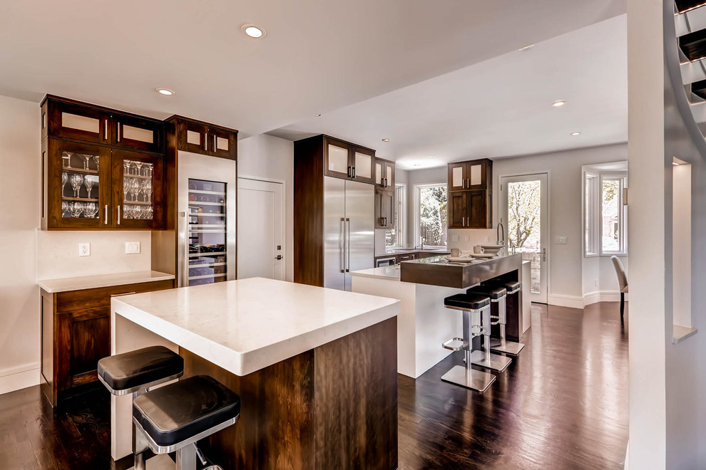 Example of a large transitional dark wood floor eat-in kitchen design in Denver with an undermount sink, shaker cabinets, dark wood cabinets, quartz countertops, stainless steel appliances and two islands