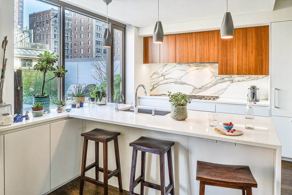 Design ideas for a contemporary galley kitchen in New York with an undermount sink, flat-panel cabinets, white cabinets, white splashback, dark hardwood floors and a peninsula.