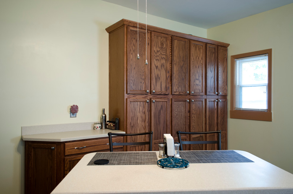 Example of a mid-sized transitional l-shaped vinyl floor eat-in kitchen design in Chicago with an integrated sink, recessed-panel cabinets, dark wood cabinets, solid surface countertops, multicolored backsplash, porcelain backsplash, stainless steel appliances and an island