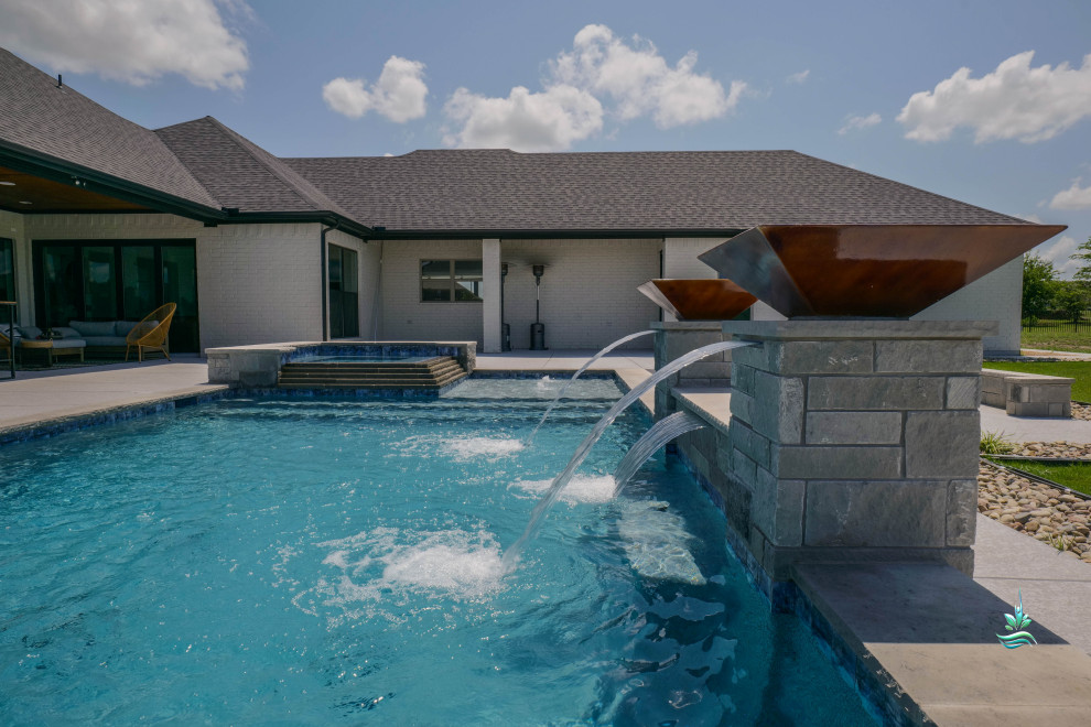 Esempio di un'ampia piscina naturale minimalista rettangolare dietro casa con pedane