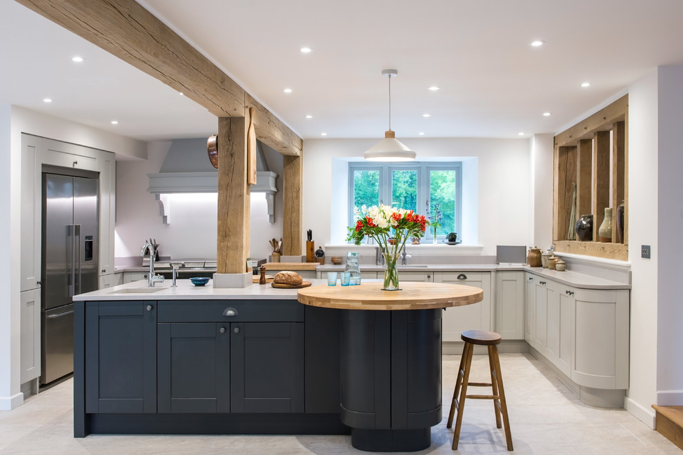 This is an example of a mid-sized country l-shaped kitchen in Cornwall with an undermount sink, shaker cabinets, grey cabinets, stainless steel appliances, with island, grey floor and grey benchtop.