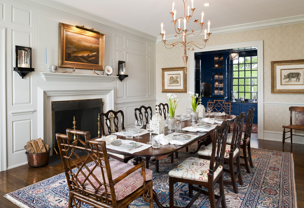 Photo of a large traditional separate dining room in Philadelphia with beige walls, dark hardwood floors, a standard fireplace and a wood fireplace surround.