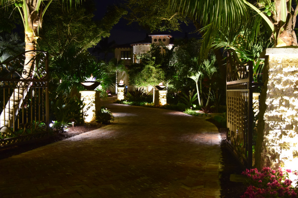 Inspiration for a large mediterranean front yard driveway in Tampa with natural stone pavers.