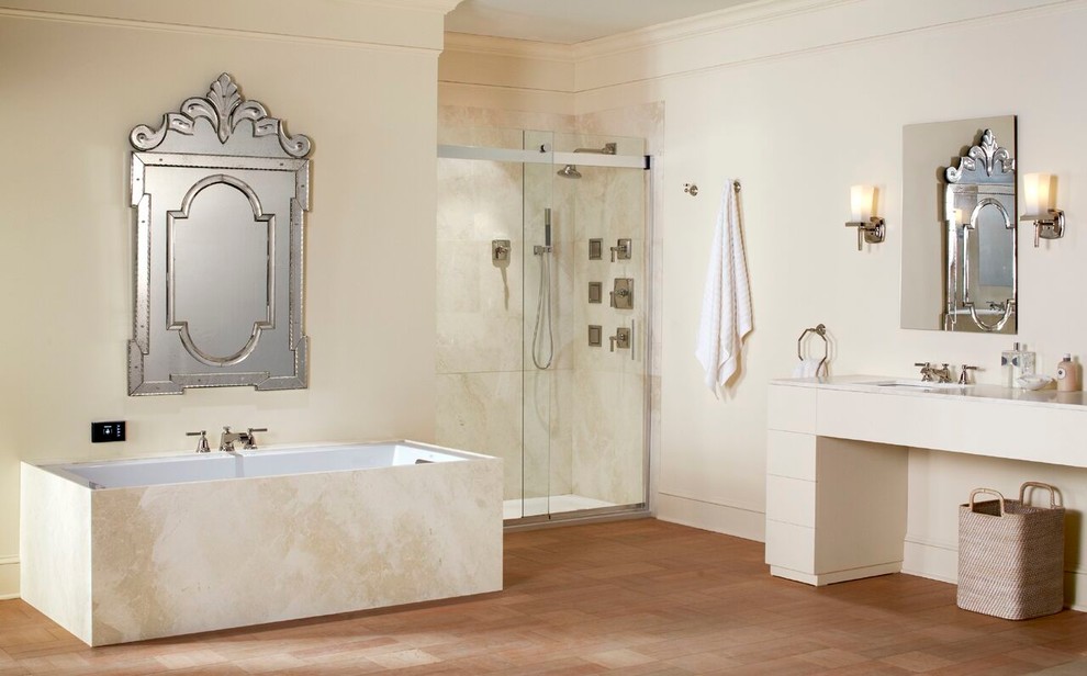 Design ideas for a mid-sized traditional master bathroom in Albuquerque with flat-panel cabinets, beige cabinets, an undermount tub, an alcove shower, beige tile, ceramic tile, beige walls, medium hardwood floors, an undermount sink, solid surface benchtops, brown floor and a sliding shower screen.