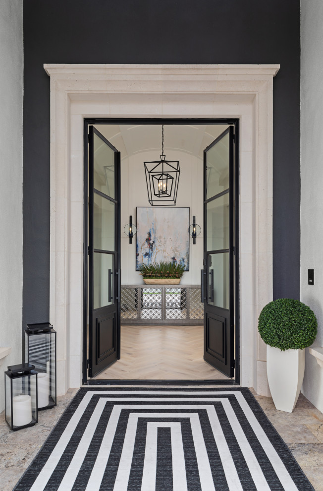 Modelo de puerta principal clásica renovada extra grande con paredes beige, suelo de madera clara, puerta doble, puerta negra y suelo beige