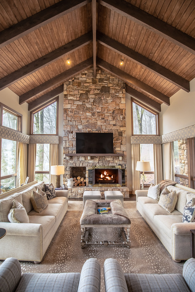 Photo of a large country open concept family room in Charlotte with a stone fireplace surround, white walls, a standard fireplace and a wall-mounted tv.