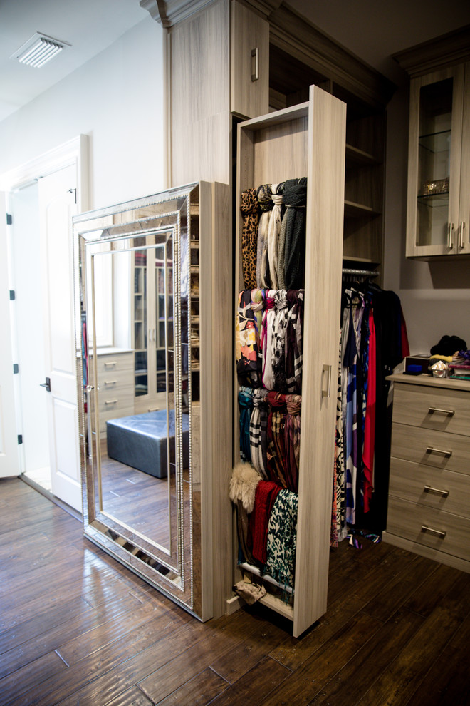 This is an example of a large contemporary women's walk-in wardrobe in Atlanta with flat-panel cabinets, grey cabinets, dark hardwood floors and brown floor.