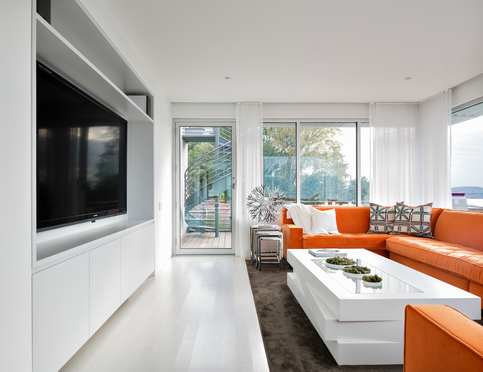 Photo of a mid-sized contemporary enclosed family room in New York with white walls, no fireplace, a wall-mounted tv, light hardwood floors and grey floor.