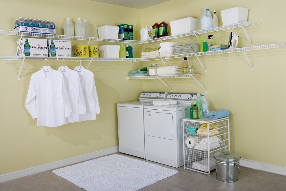 Large traditional l-shaped dedicated laundry room in Other with open cabinets, white cabinets, yellow walls, concrete floors, a side-by-side washer and dryer and grey floor.