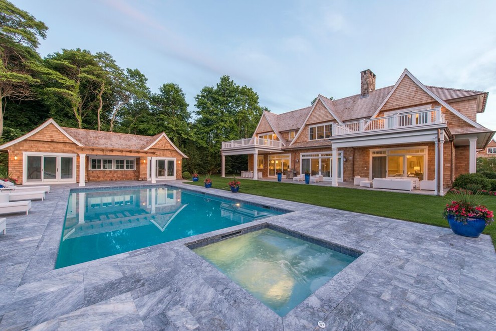 Example of a large backyard stone and rectangular lap hot tub design in New York