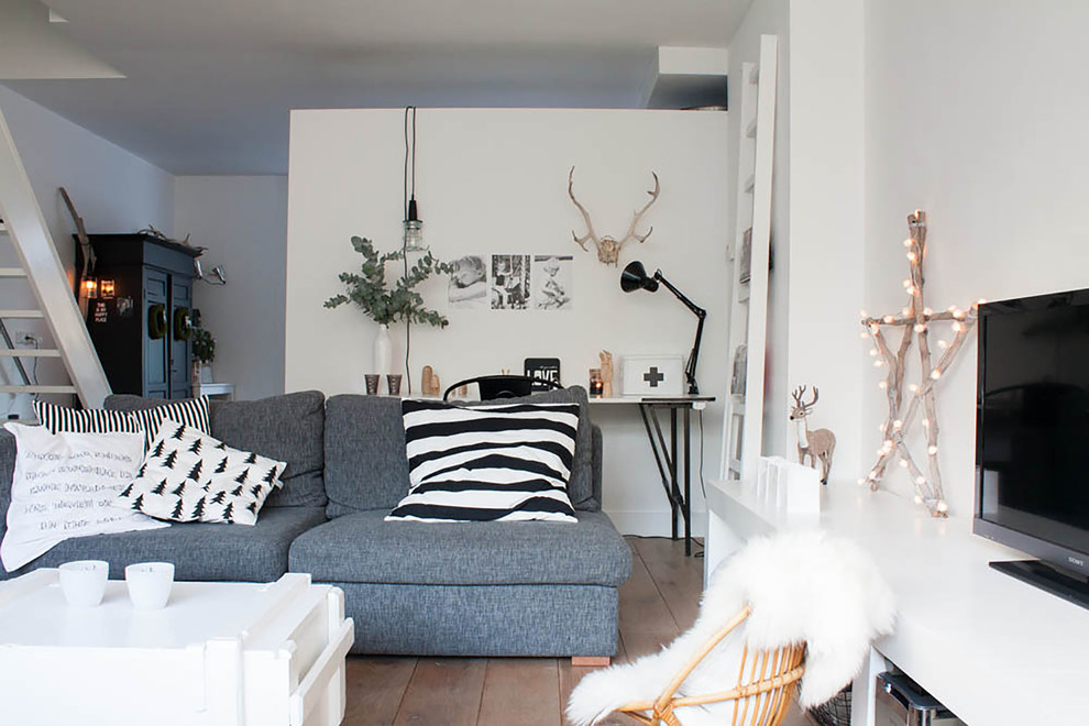 Eclectic living room in Amsterdam with white walls and a freestanding tv.