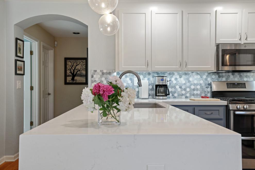 Example of a minimalist l-shaped ceramic tile and brown floor eat-in kitchen design in Sacramento with an undermount sink, white cabinets, quartz countertops, multicolored backsplash, stainless steel appliances, an island and gray countertops