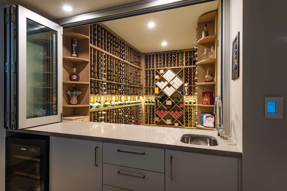 This is an example of a contemporary wine cellar in Sydney with storage racks.