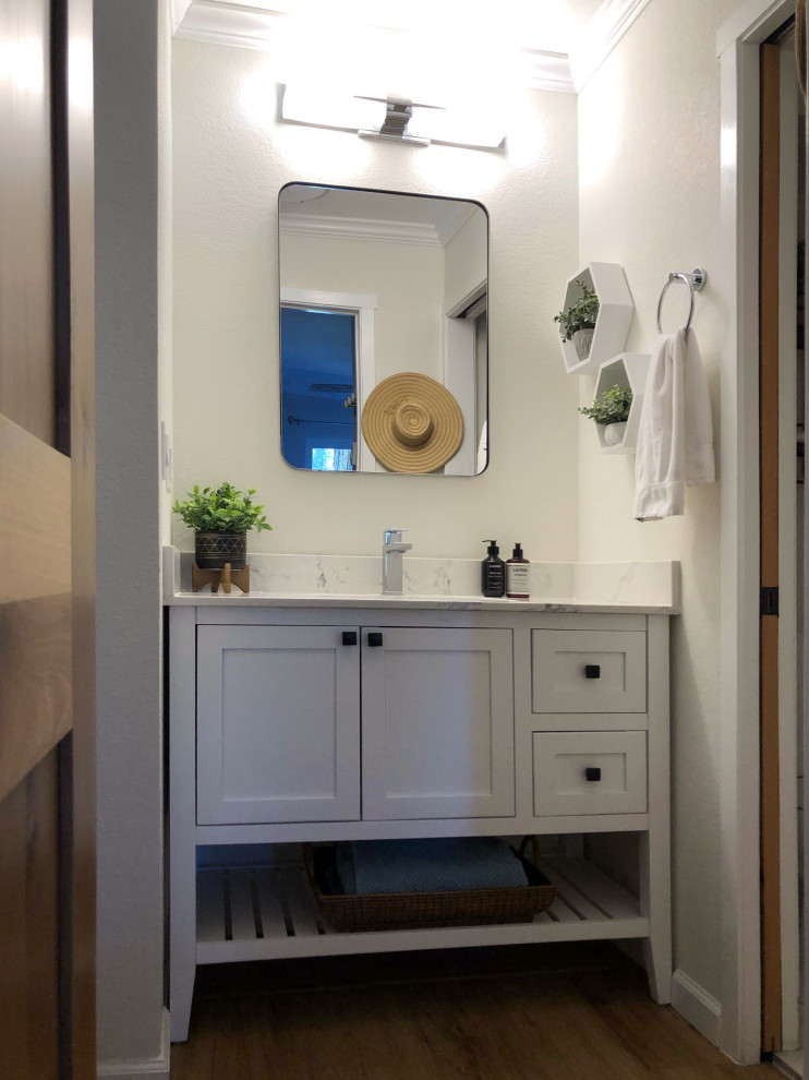 This is an example of a small contemporary master bathroom in San Francisco with shaker cabinets, white cabinets, an alcove tub, an alcove shower, a one-piece toilet, white tile, porcelain tile, white walls, vinyl floors, an undermount sink, quartzite benchtops, white floor, a sliding shower screen, white benchtops, an enclosed toilet, a single vanity and a freestanding vanity.