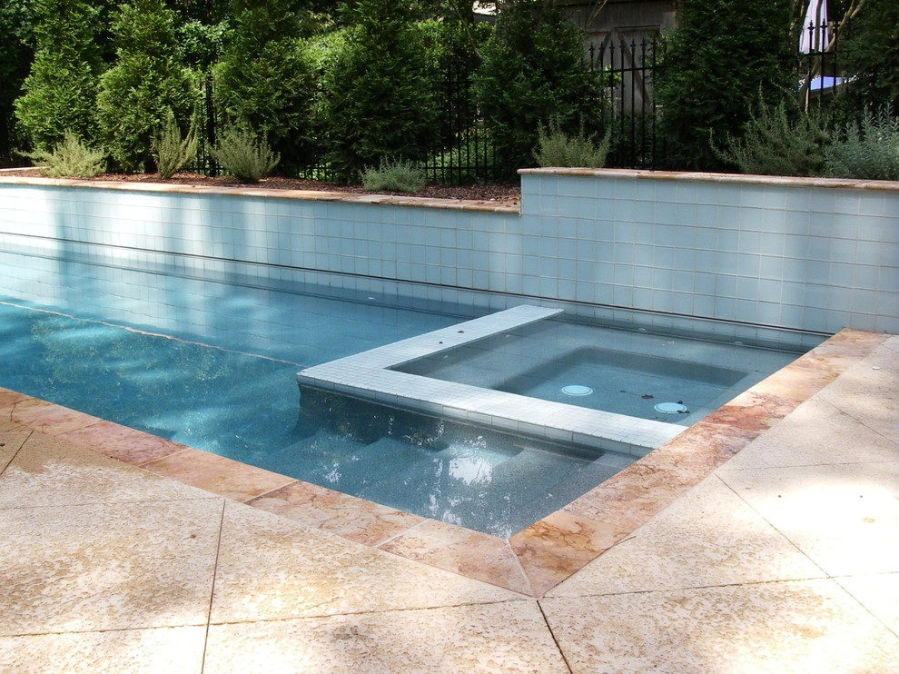 This is an example of a mid-sized traditional backyard rectangular lap pool in Atlanta with a hot tub and concrete slab.