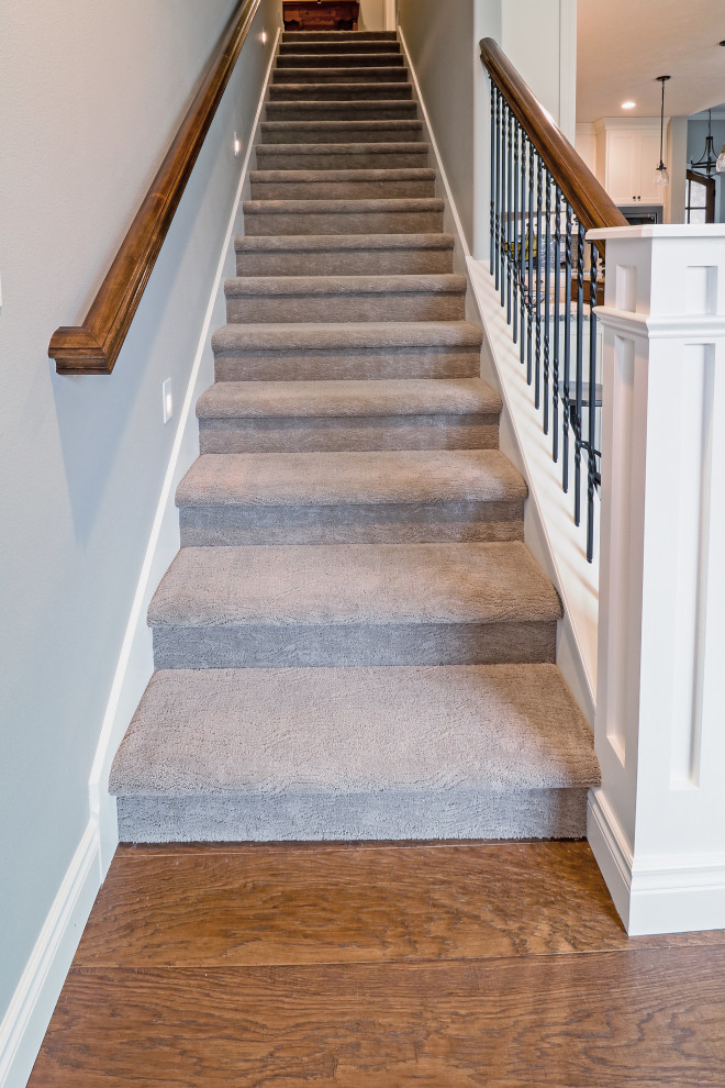 Inspiration for a large traditional carpeted u-shaped staircase in Other with carpet risers and metal railing.