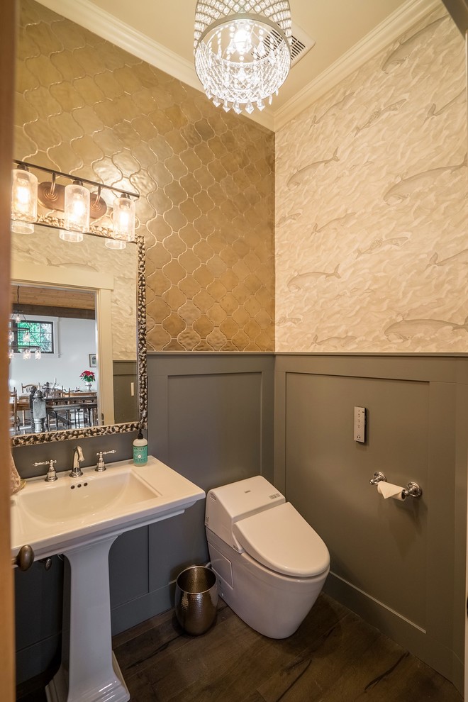 Mid-sized transitional powder room in Seattle with a one-piece toilet, beige tile, metal tile, beige walls, dark hardwood floors, a pedestal sink, solid surface benchtops, brown floor and white benchtops.