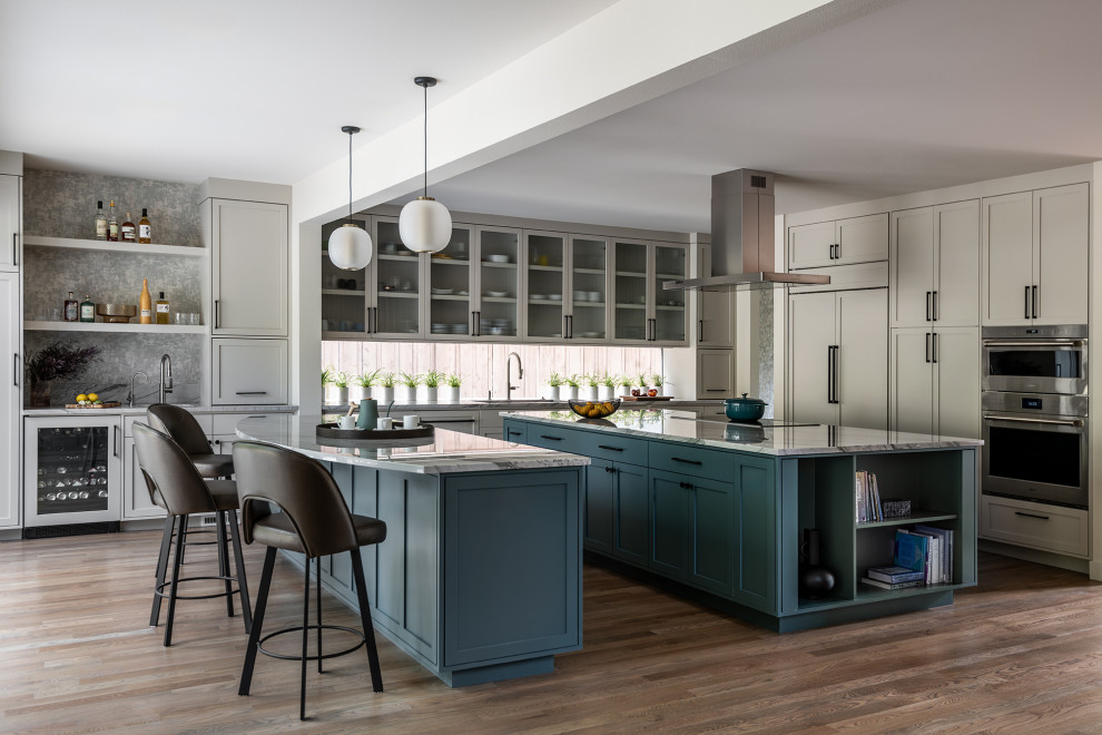 Inspiration for a transitional u-shaped dark wood floor and brown floor kitchen remodel in Seattle with an undermount sink, shaker cabinets, gray cabinets, window backsplash, stainless steel appliances, two islands and gray countertops