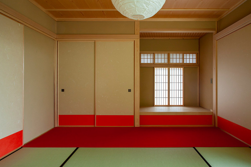 Inspiration for a mid-sized asian guest bedroom in Other with red walls, tatami floors, no fireplace and red floor.