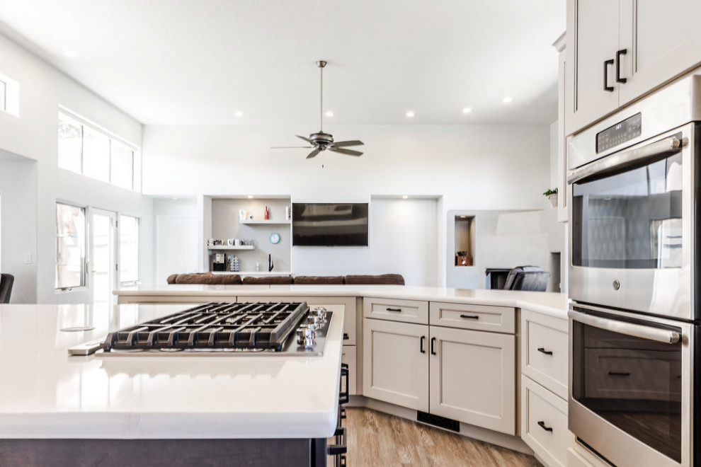 Inspiration for a large transitional u-shaped vinyl floor and gray floor eat-in kitchen remodel with an undermount sink, shaker cabinets, gray cabinets, quartzite countertops, green backsplash, subway tile backsplash, stainless steel appliances, an island and white countertops